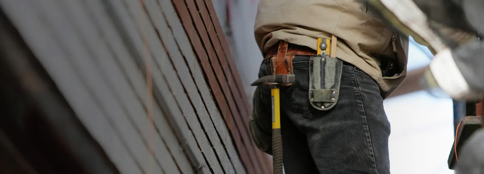 Operaio al lavoro in cantiere con cintura porta-attrezzi